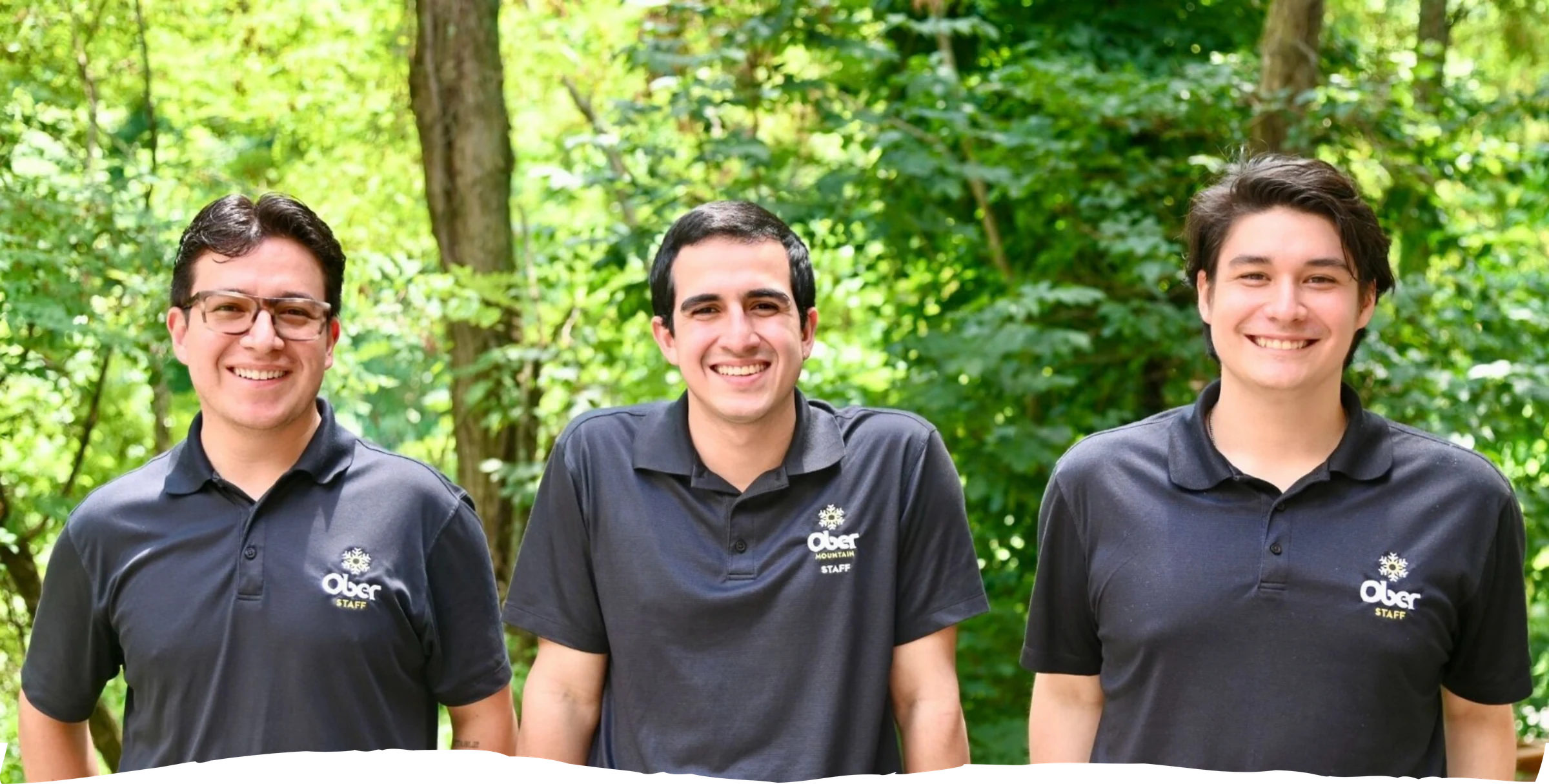 Tres participantes de Ober Mountain frente a un entorno verde